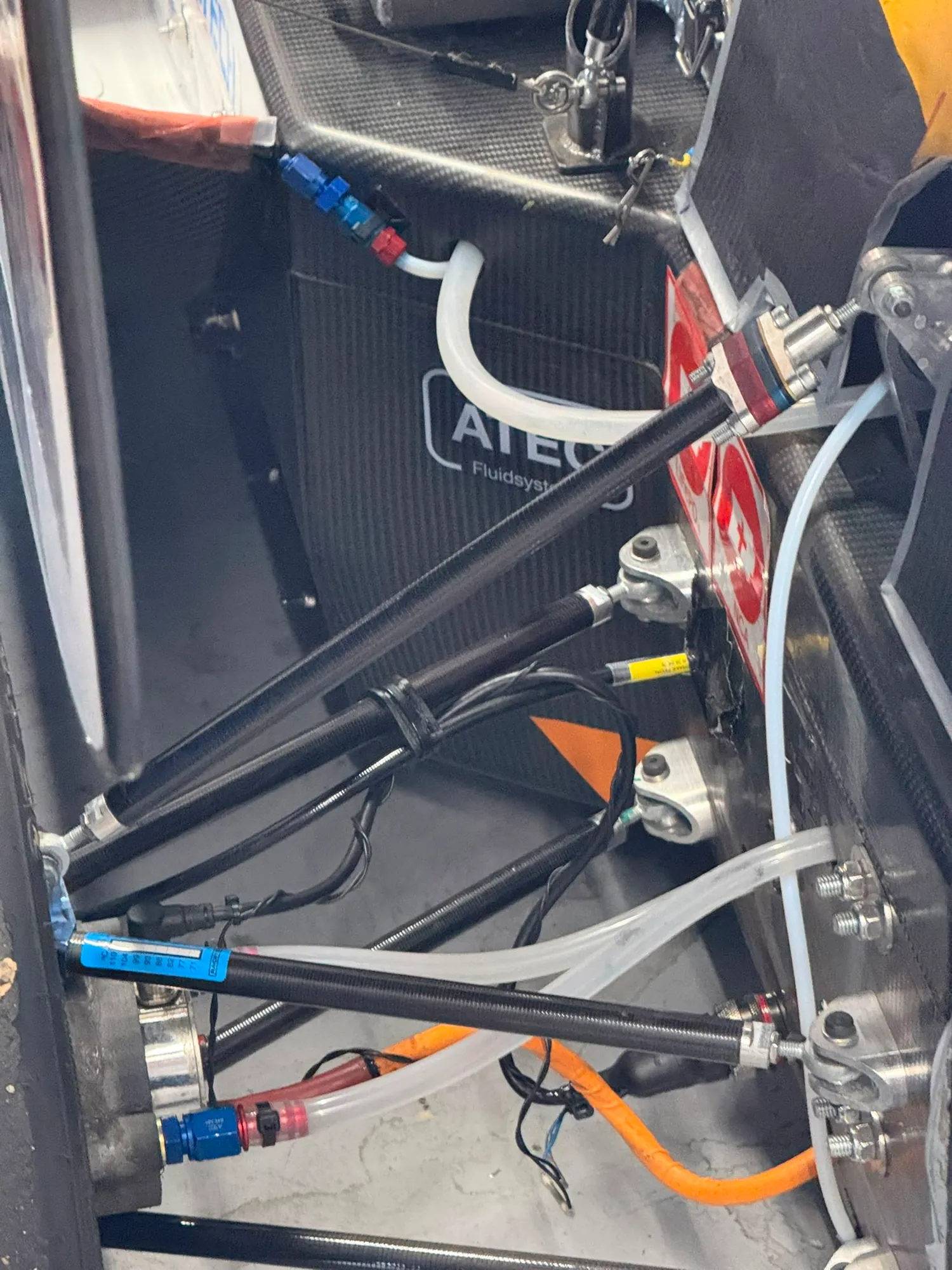 A front corner on the car: wishbones, the pushrod running inboard from the upright, and the brake and hub behind them